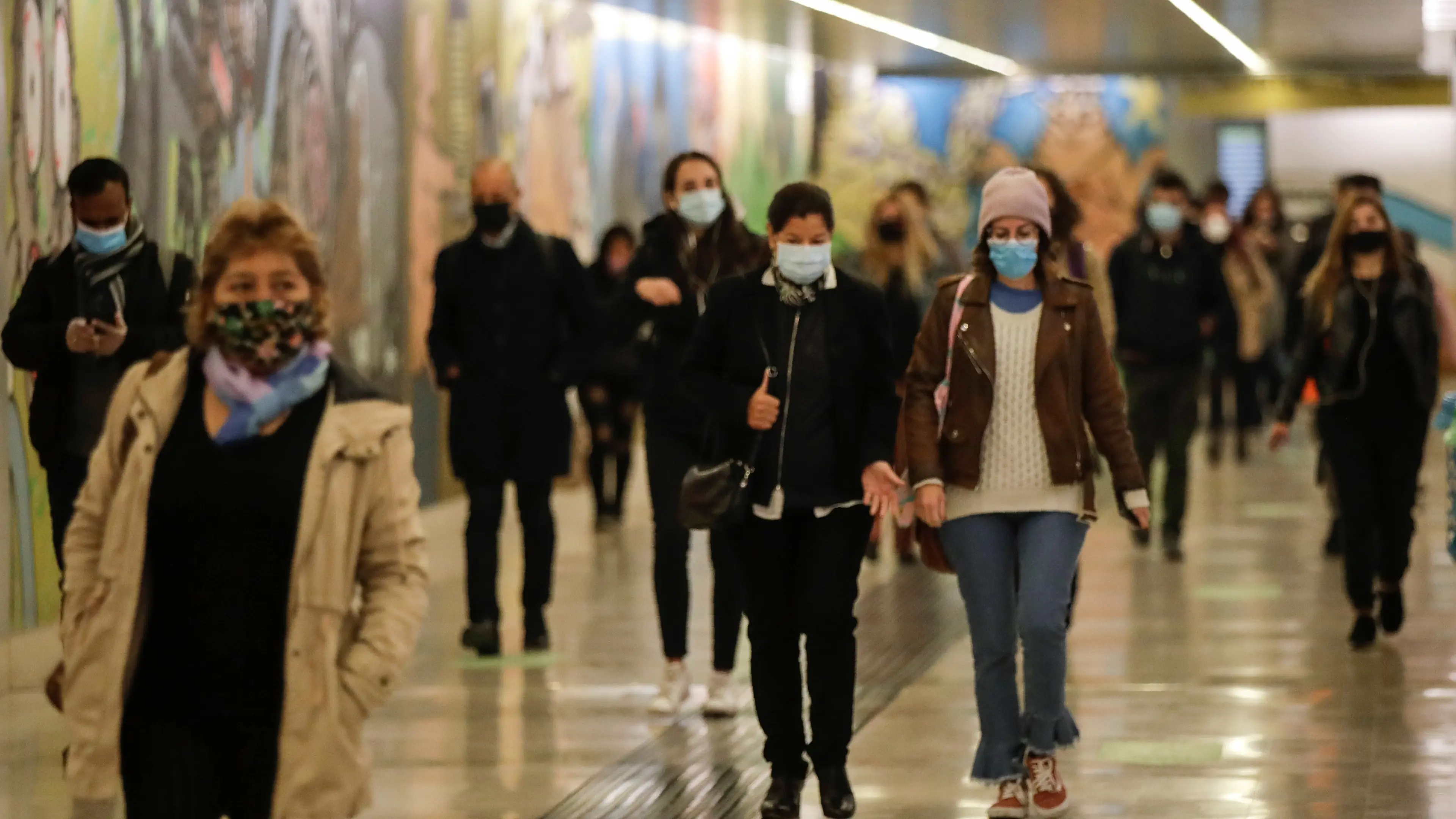 People wear masks to prevent the spread of COVID-19 as they walk in the underground of the Garibaldi railway station, in Milan, Italy, Tuesday, Oct. 13, 2020. Italian Premiere Giuseppe Conte ordered strict new anti-COVID measures early Tuesday, including limits on private gatherings and a ban on casual pickup sports. (AP Photo/Luca Bruno)